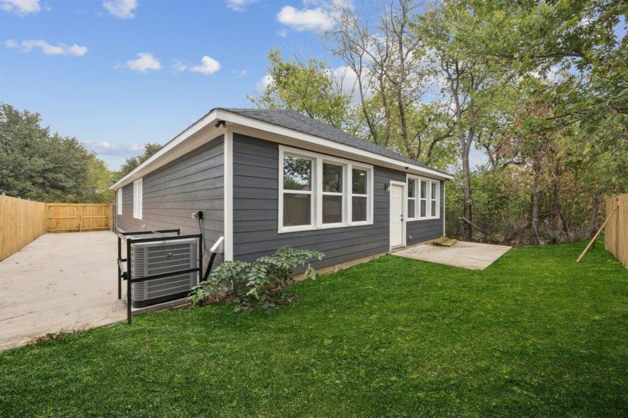 Back of property featuring a fenced backyard, a patio area, and roof with shingles