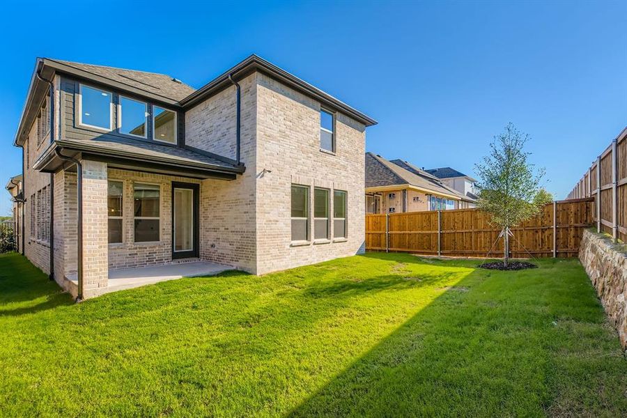 Rear view of property featuring a patio area, brick siding, and a fenced backyard