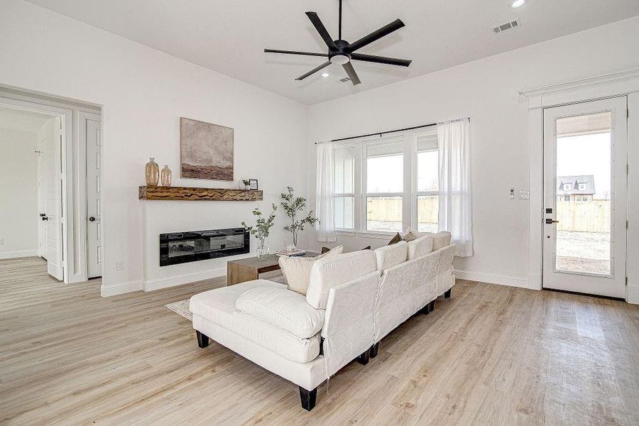 Living area featuring visible vents, recessed lighting, light wood-style floors, baseboards, and ceiling fan