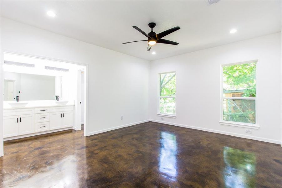 Unfurnished bedroom with sink, ensuite bath, and ceiling fan