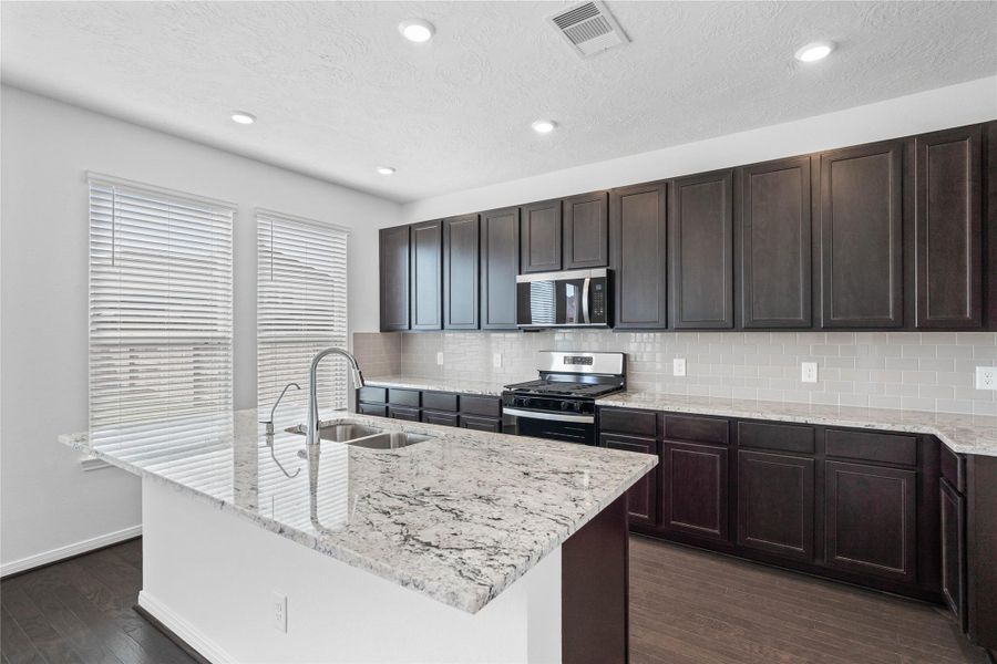 Beautiful view of the kitchen island with granite countertop, extended breakfast bar.