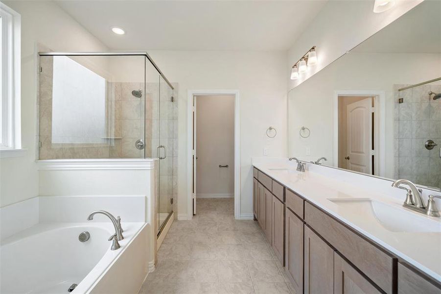 Bathroom featuring a garden tub, double vanity, a stall shower, light tile patterned floors, and recessed lighting