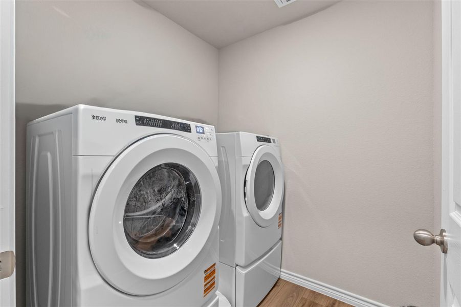 Laundry room with wood finished floors and washing machine and dryer