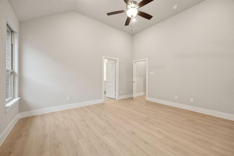 Unfurnished room with vaulted ceiling, light hardwood / wood-style floors, and ceiling fan