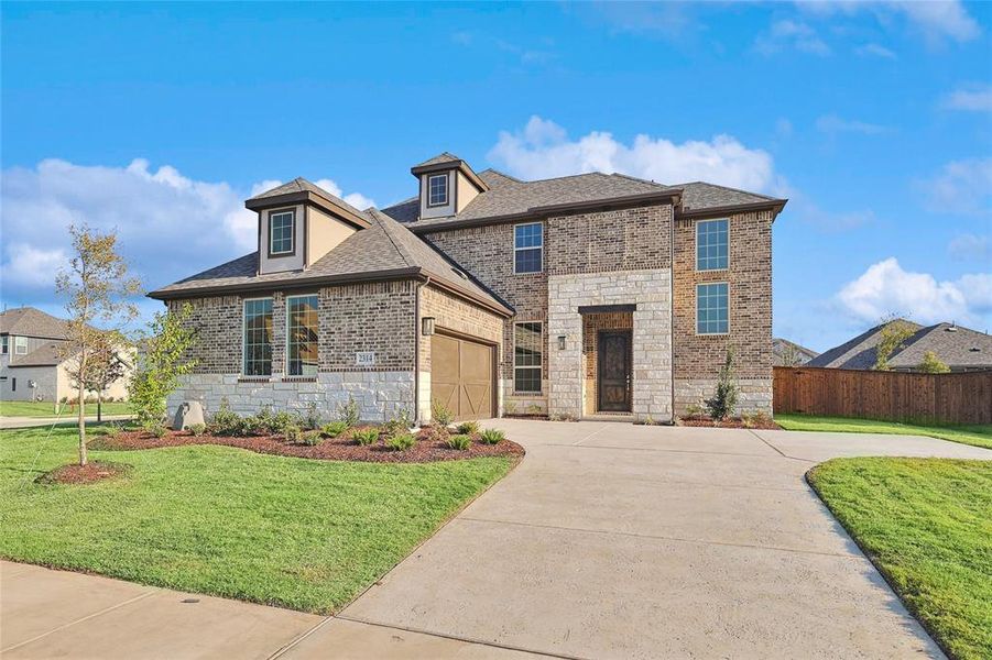 View of front of property with a front lawn and a garage