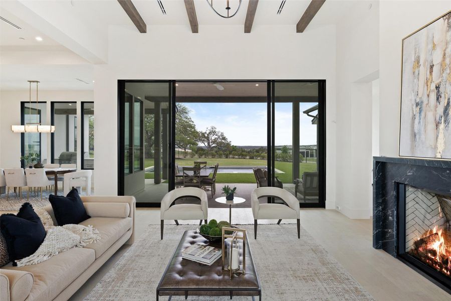Living area with baseboards, visible vents, beamed ceiling, wood finished floors, and a fireplace Living area with baseboards, visible vents, beamed ceiling, wood finished floors, and a fireplace