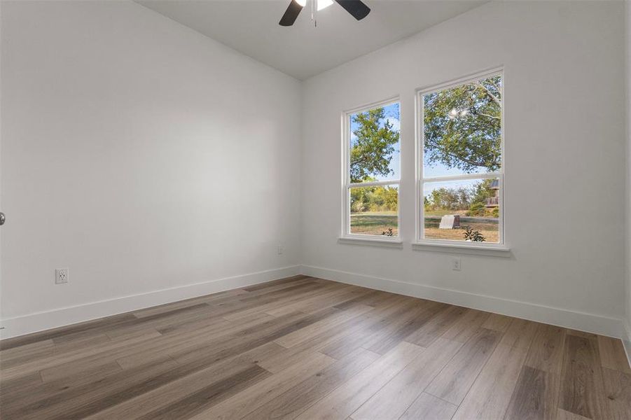Empty room with light wood-style flooring and ceiling fan