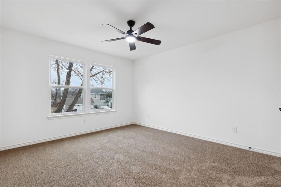 Carpeted spare room featuring ceiling fan