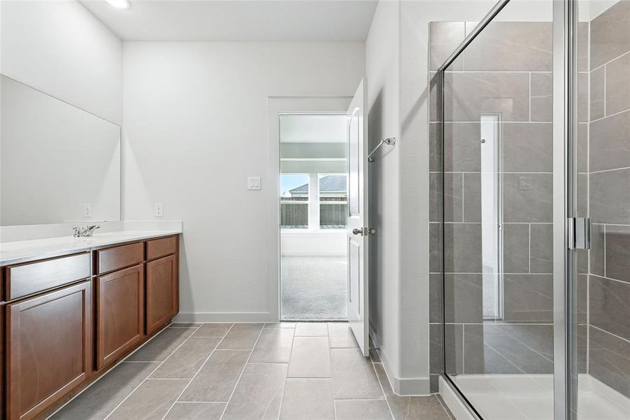 Bathroom with vanity, a shower stall, and light tile patterned floors Bathroom with vanity, a shower stall, and light tile patterned floors