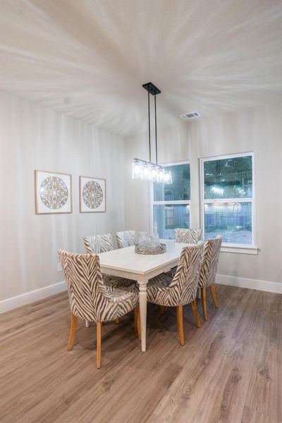 Dining room featuring wood finished floors, baseboards, and healthy amount of natural light