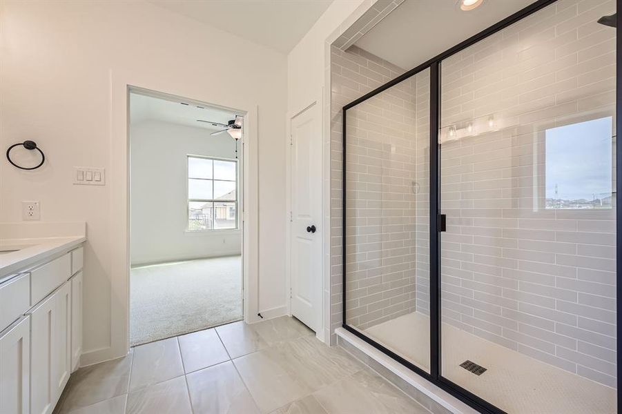 Bathroom featuring a shower stall, vanity, and a ceiling fan Bathroom featuring a shower stall, vanity, and a ceiling fan