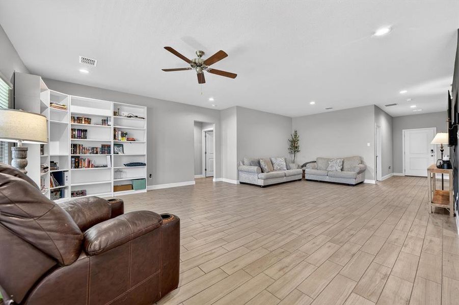 Spacious living area featuring wood-finish plank flooring and light gray walls