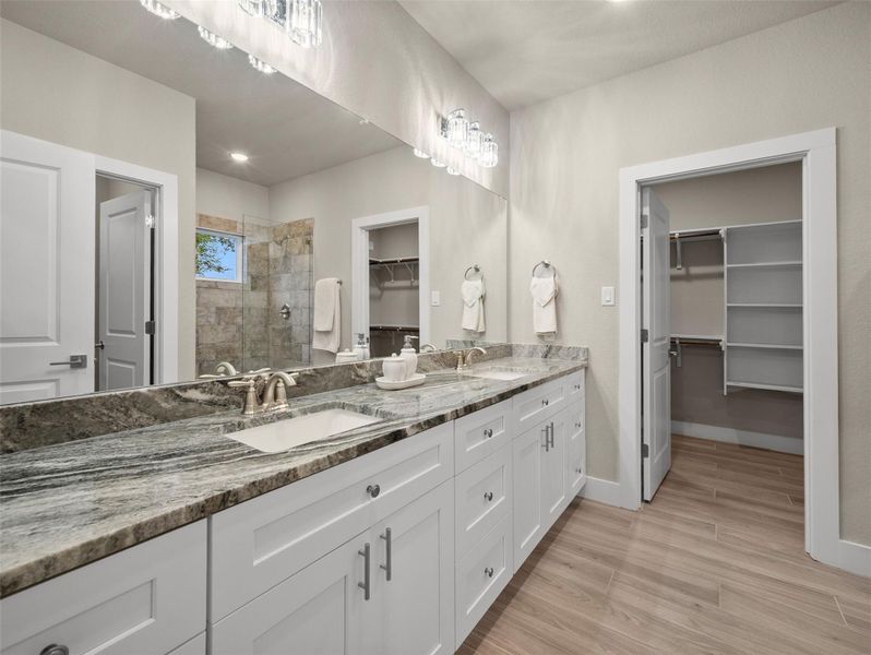 Bathroom featuring a walk in closet, double vanity, a stall shower, light wood-type flooring, and recessed lighting Bathroom featuring a walk in closet, double vanity, a stall shower, light wood-type flooring, and recessed lighting