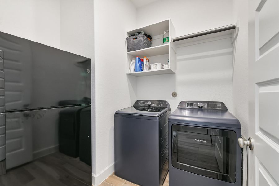 Laundry room with drying rod and room for a full refrigerator. Laundry room with drying rod and room for a full refrigerator.