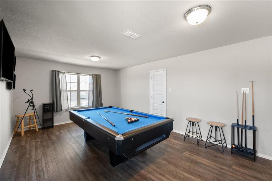 Game room featuring a textured ceiling, dark hardwood / wood-style floors, and billiards