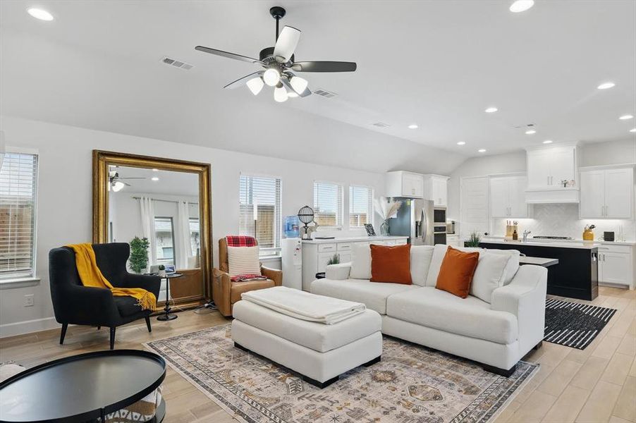 Living area featuring visible vents, plenty of natural light, and ceiling fan