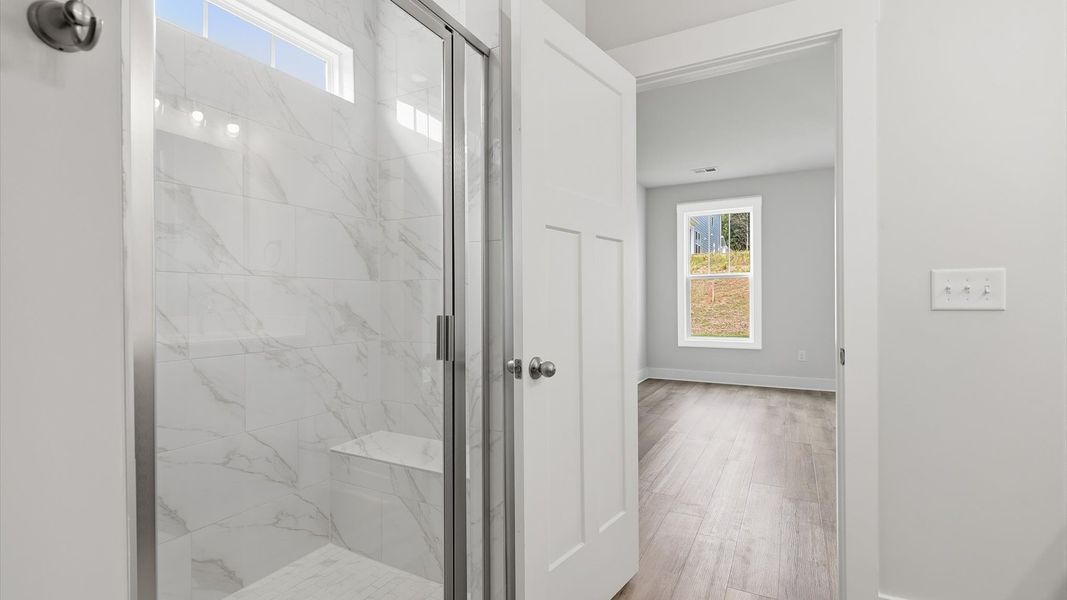 Exceptional en-suite with dual vanity and glass-enclosed tiled walk-in shower for superior everyday comfort