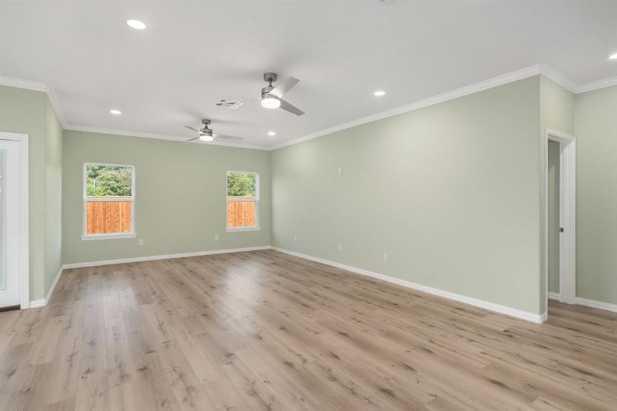 Empty room with ornamental molding, light hardwood / wood-style flooring, and ceiling fan