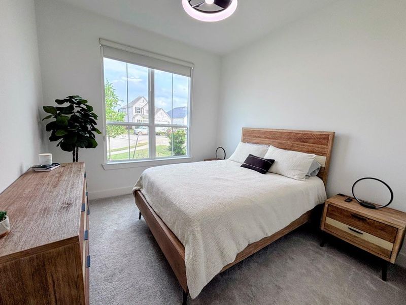 The bedroom #2 is bright and inviting, featuring a large window with a view of the neighborhood.