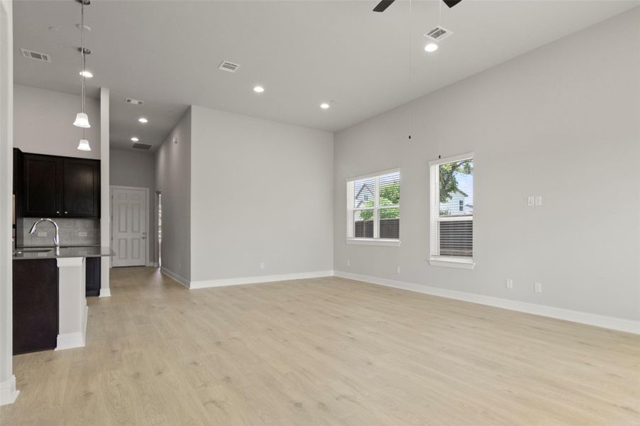 Unfurnished living room with light wood-style flooring, ceiling fan, and recessed lighting