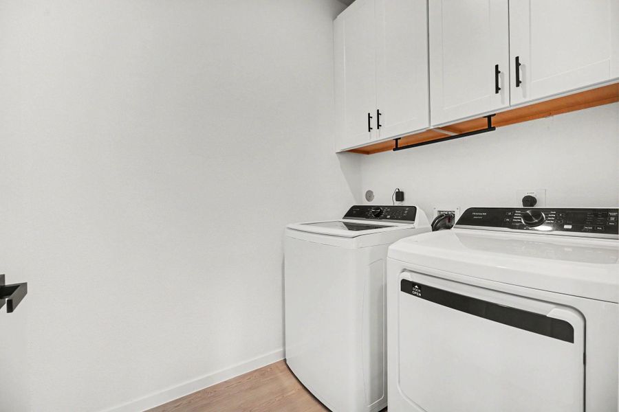 Laundry room with upper cabinetry providing additional storage for supplies and household essentials. Laundry room with upper cabinetry providing additional storage for supplies and household essentials.