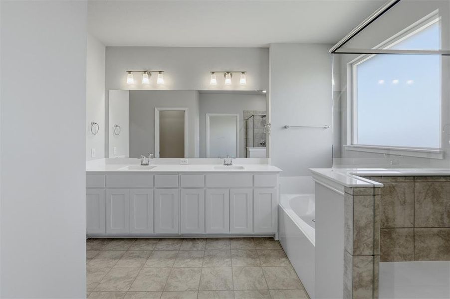 Full bath featuring a shower stall, double vanity, and a bath