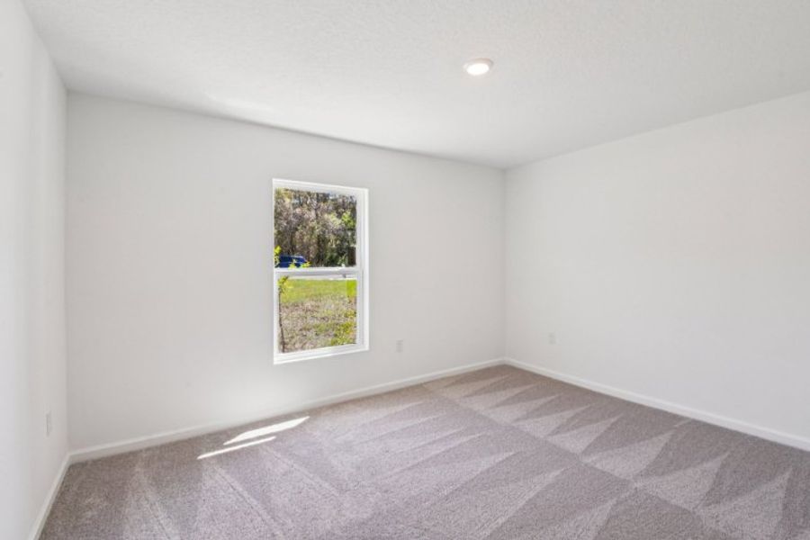 A room with a window and a rug.