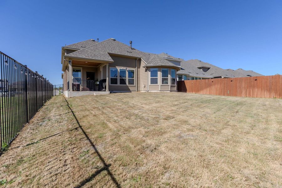 Back of property featuring a patio area, a fenced backyard, and roof with shingles