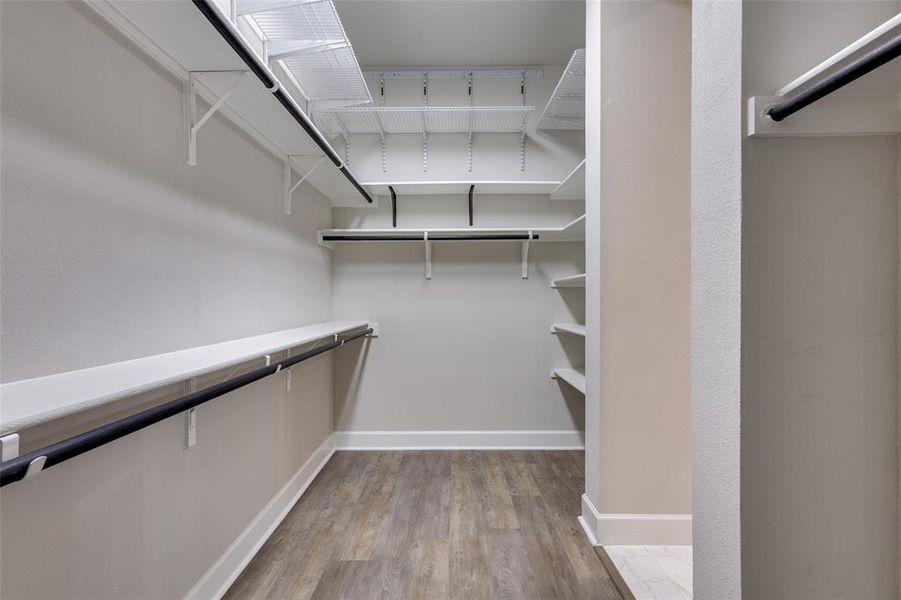 Primary Closet with lots of storage shelving and hanging rods Primary Closet with lots of storage shelving and hanging rods