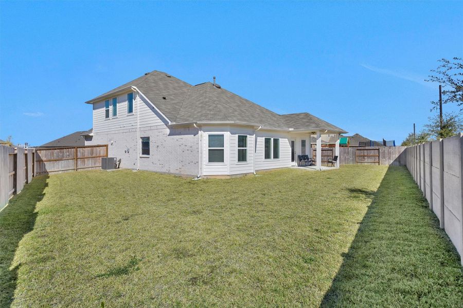 This expansive backyard offers wide open green space, full fencing, and a covered patio—providing the perfect setting for outdoor activities, entertaining, and future enhancements.