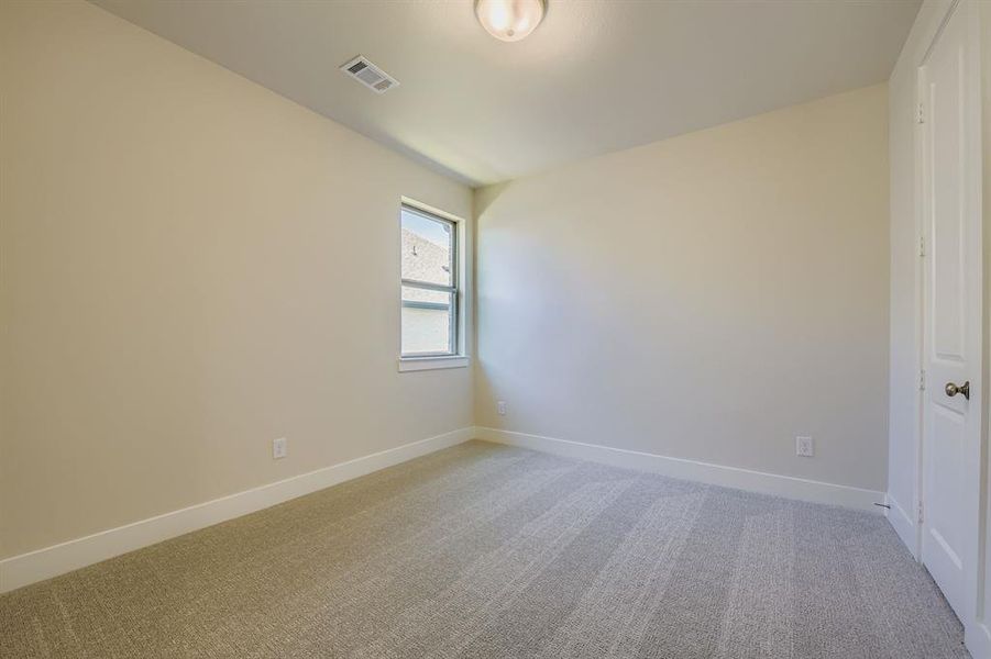 Spare room featuring light colored carpet and baseboards