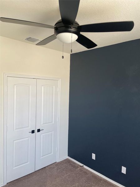 Unfurnished bedroom featuring carpet flooring, a closet, a textured ceiling, and ceiling fan Unfurnished bedroom featuring carpet flooring, a closet, a textured ceiling, and ceiling fan