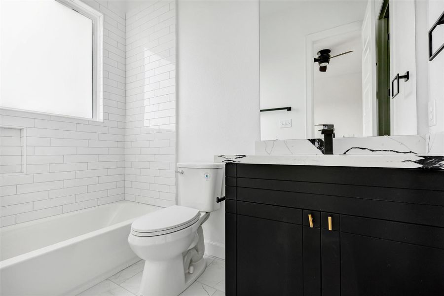 A closer look of this well-appointed bathroom, featuring a tub and shower combo, a vanity mirror, a single sink, and a convenient closet for added storage. (Representation of previously built homes. Actual colors and finishes will vary.) A closer look of this well-appointed bathroom, featuring a tub and shower combo, a vanity mirror, a single sink, and a convenient closet for added storage. (Representation of previously built homes. Actual colors and finishes will vary.)