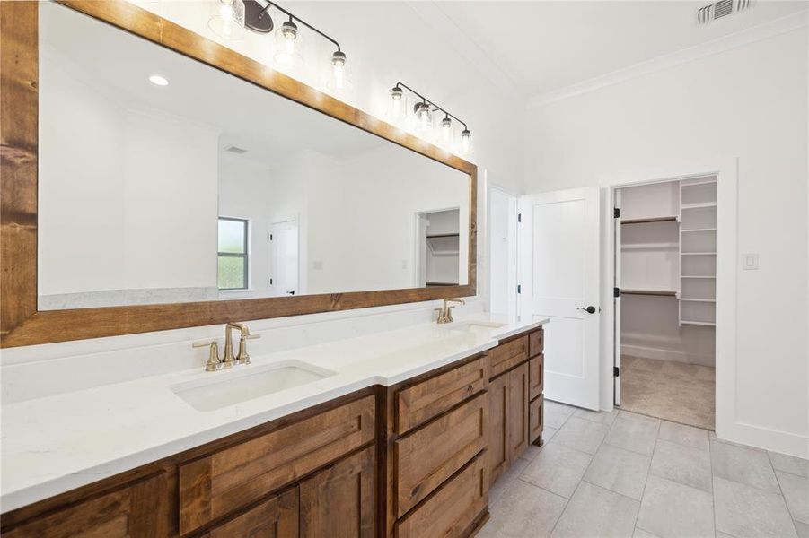 Bathroom featuring dual vanity, tile patterned flooring, and ornamental molding