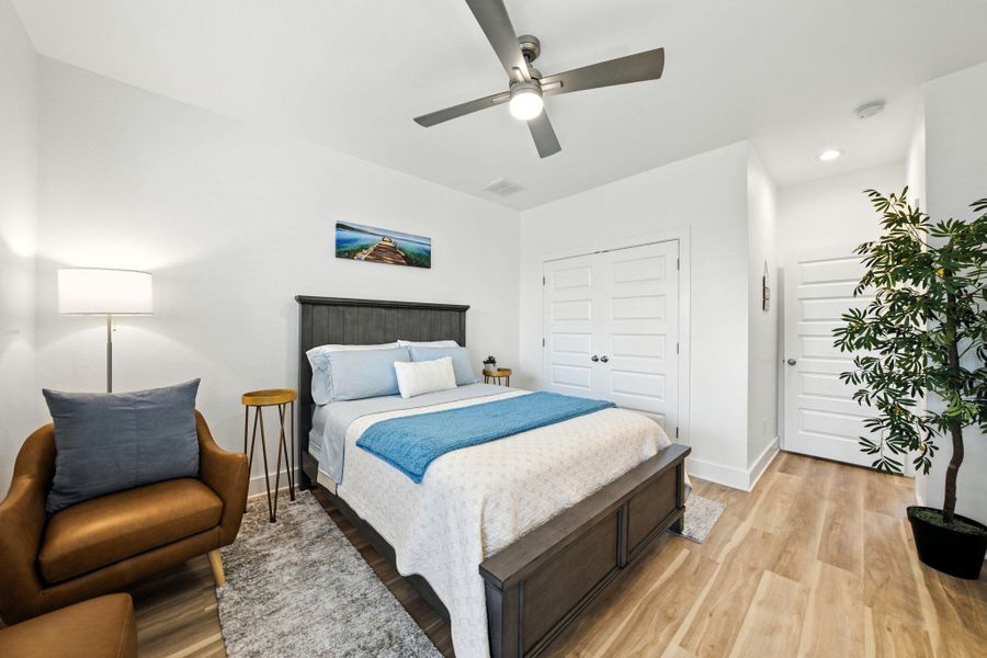Expansive primary bedroom with ensuite bath, light vinyl plank floors, a large closet, ceiling fan, and recessed lighting Expansive primary bedroom with ensuite bath, light vinyl plank floors, a large closet, ceiling fan, and recessed lighting