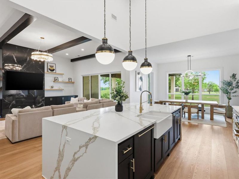Expansive kitchen island with a waterfall countertop and integrated farmhouse sink