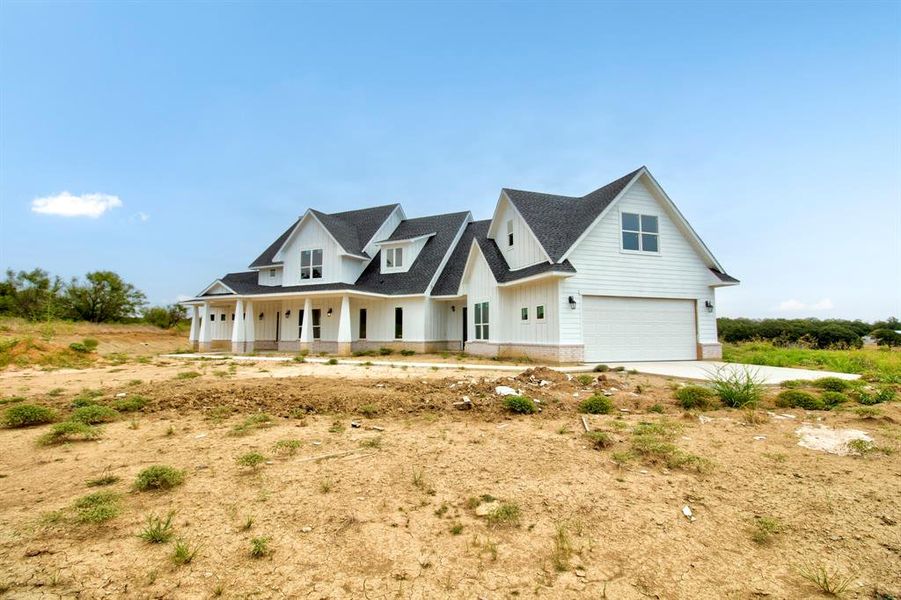 Modern farmhouse style home featuring driveway, a porch, an attached garage, board and batten siding, and roof with shingles Modern farmhouse style home featuring driveway, a porch, an attached garage, board and batten siding, and roof with shingles