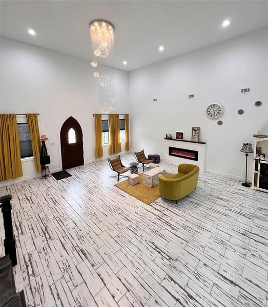 Living room with a notable chandelier and light hardwood / wood-style floors