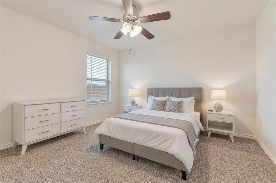 Bedroom featuring light colored carpet and a ceiling fan