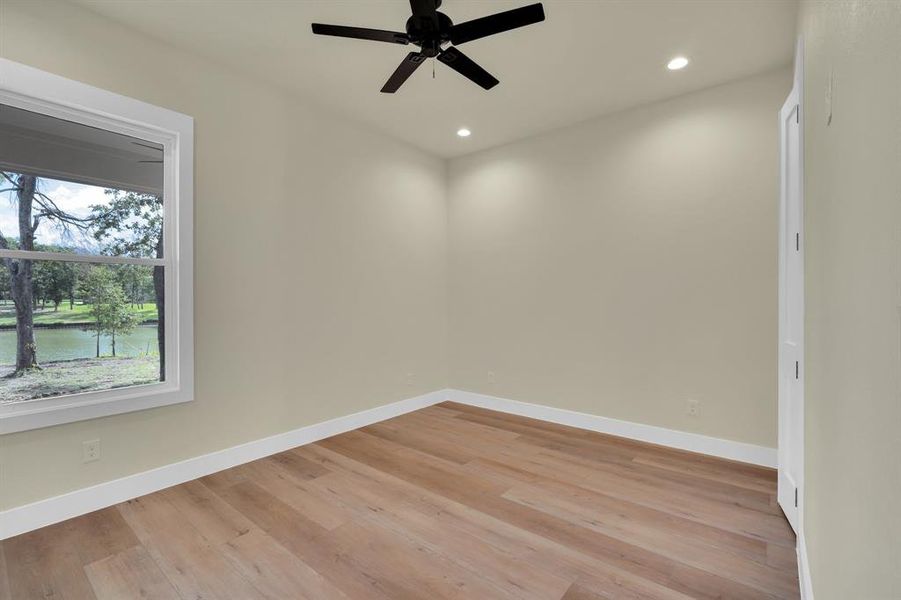 Unfurnished room with ceiling fan, light wood-type flooring, and a healthy amount of sunlight