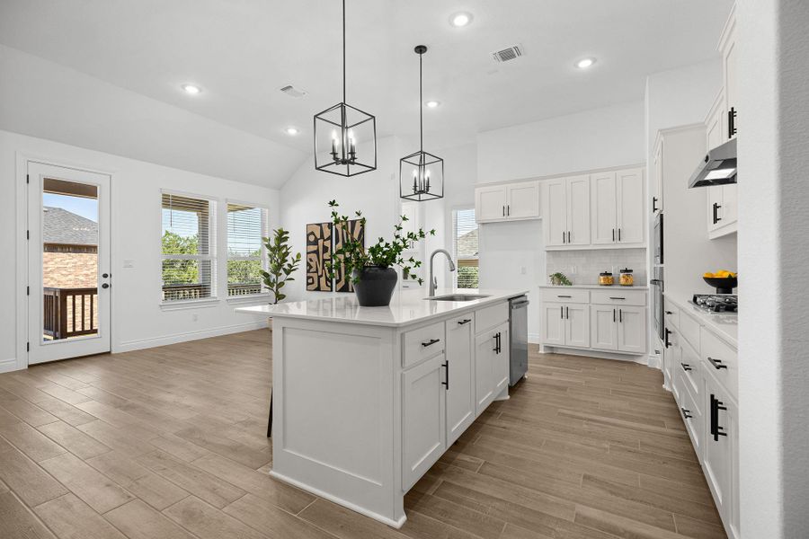 Kitchen with backsplash, healthy amount of natural light, a kitchen island with sink, light wood-type flooring, and recessed lighting