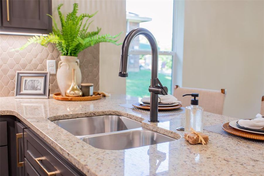 Detailed view of light stone countertops and tasteful backsplash Detailed view of light stone countertops and tasteful backsplash