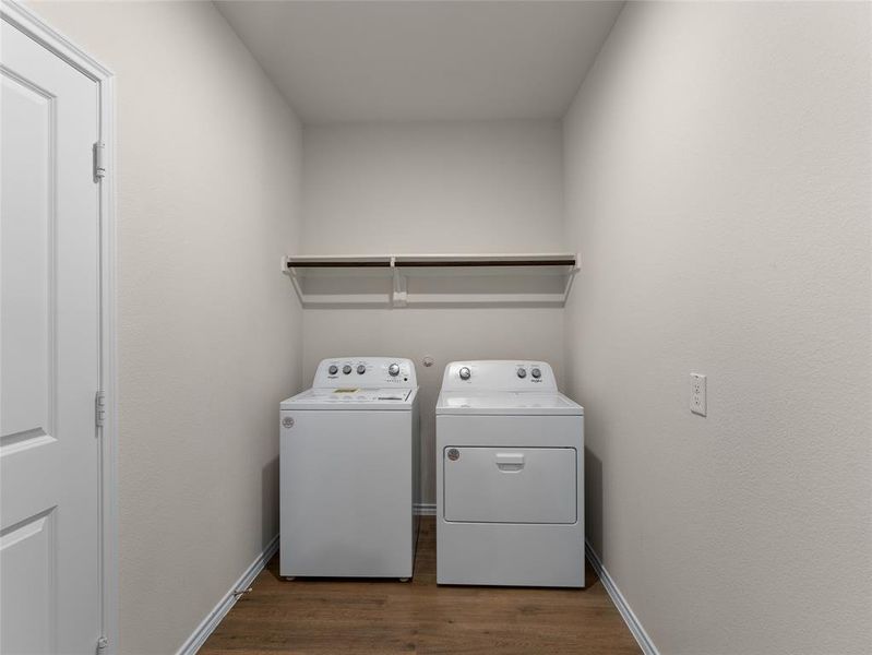 Clothes washing area featuring dark wood-type flooring and separate washer and dryer