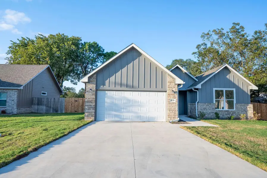 Craftsman-style home featuring board and batten siding, driveway, and a garage Craftsman-style home featuring board and batten siding, driveway, and a garage