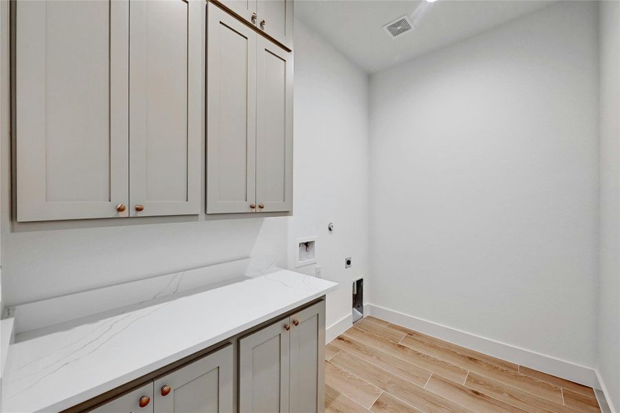 Making laundry day a little bit easier - this laundry room comes with plenty of counter space and custom cabinets!