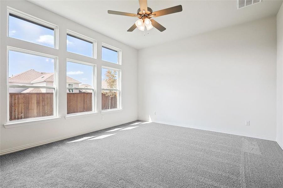 Carpeted spare room featuring ceiling fan