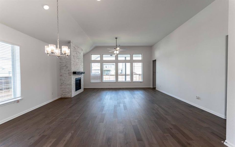 Spacious room featuring wood-finish flooring and vaulted ceilings