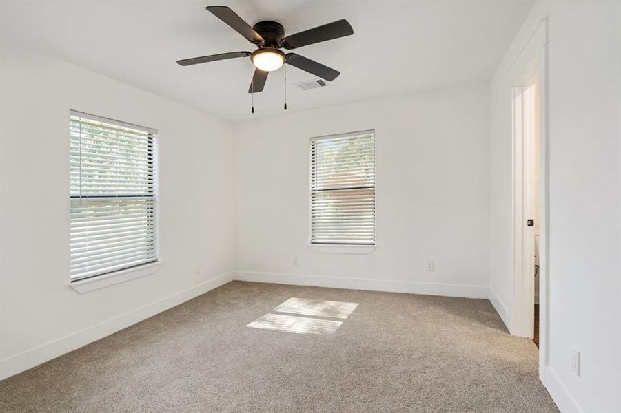 Carpeted empty room with ceiling fan