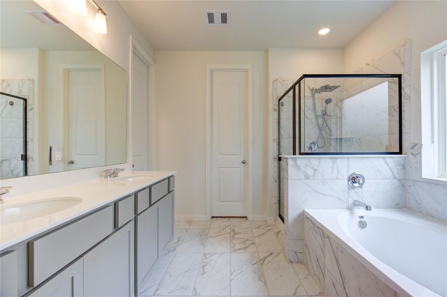 Primary spa-like bath with huge tub, separate shower and double sinks.