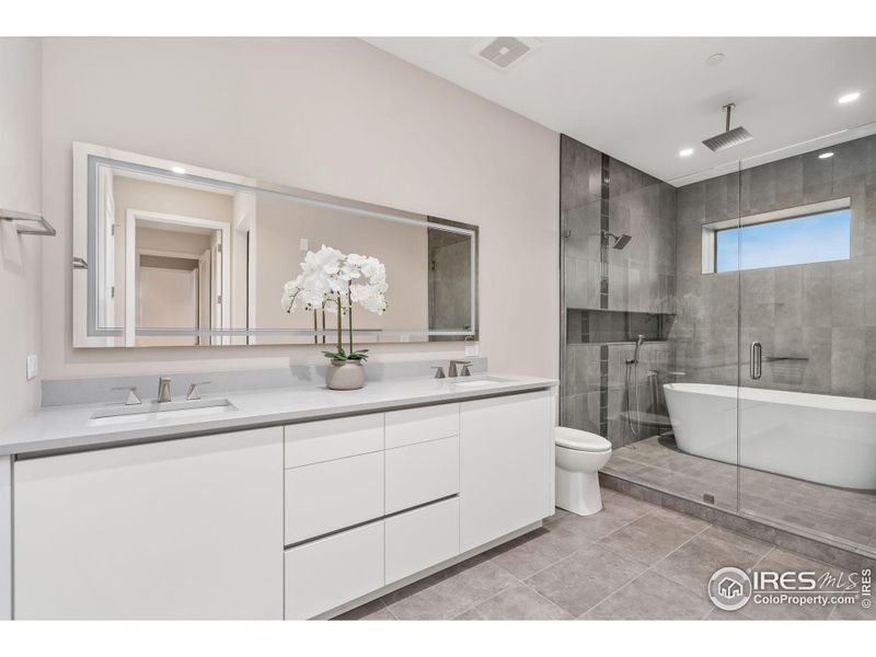 Euro-like bath and shower combo with multiple shower heads and back-lit, color adjusted, steam proof mirror.